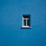 Compact outward-opening style framed against a bold blue wall, combining function with striking visual contrast.