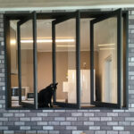 Wide-open sliding panels bring in fresh air and light - even the cat approves.