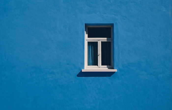 Compact outward-opening style framed against a bold blue wall, combining function with striking visual contrast.